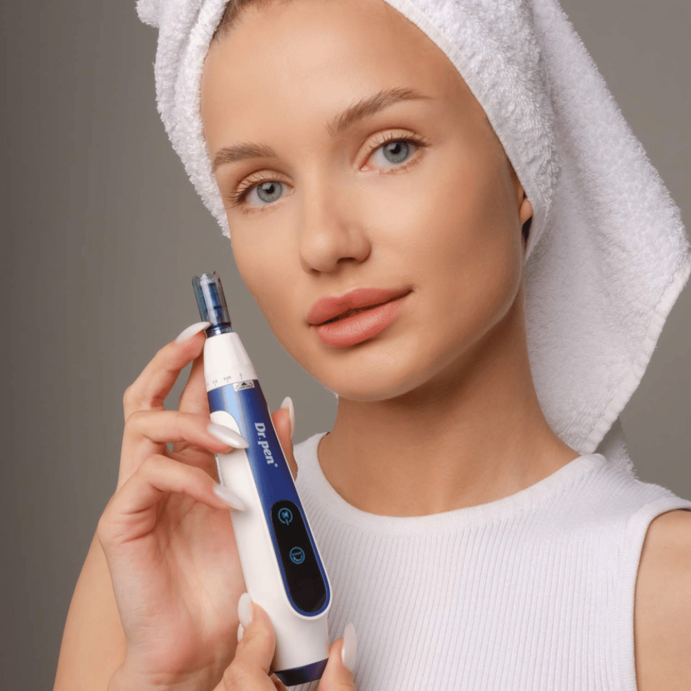 Frau mit Handtuch um den Kopf hält Dr. Pen A11 microneedling-Stift – professionelles Hautpflegegerät für glattere und festere Haut.
